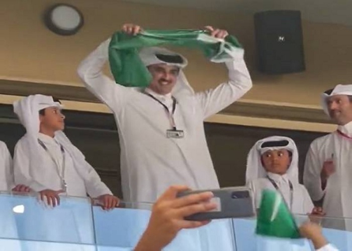 أمير قطر يتوشح بعلم السعودية خلال تشجيعه للأخضر